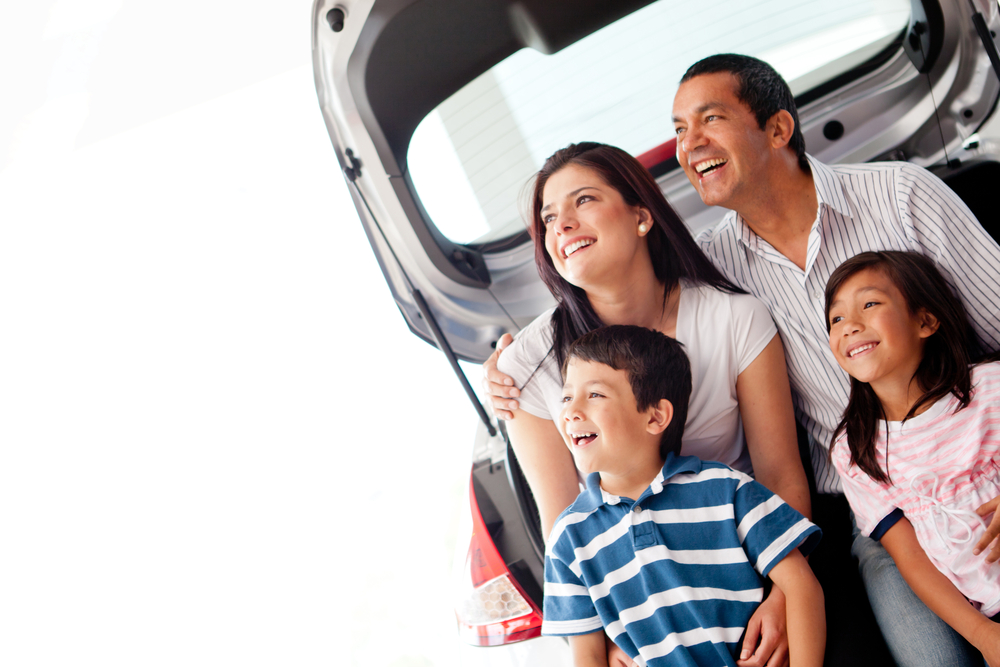 Happy family with their new car smiling